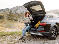 Jeune femme en vacances à la montagne avec sa voiture