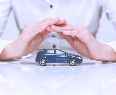 Concept d'assurance automobile - femme qui protege une voiture avec ses mains