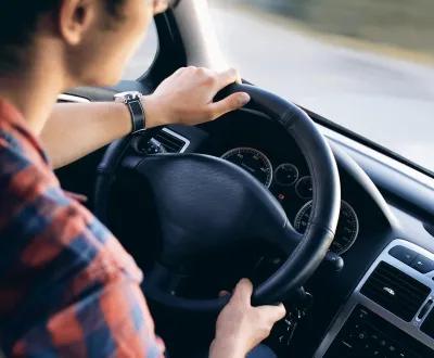 Prise de vue par le haut d'un homme tenant le volant de sa voiture