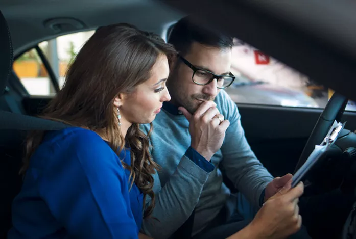 Couple qui réfléchit à l'achat de sa prochaine voiture