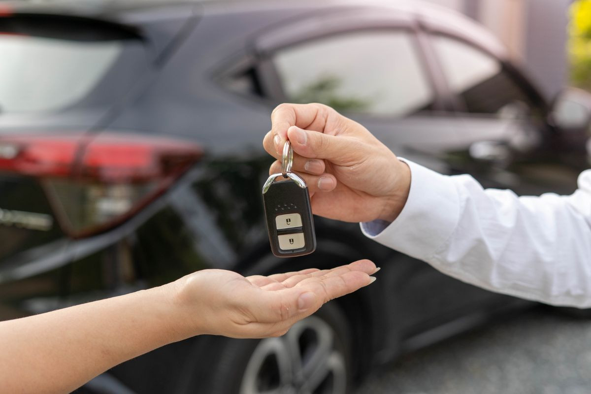 "Un individu remettant les clés d'une voiture à une autre personne, illustrant l'opportunité d'un essai gratuit pour un véhicule avant l'achat