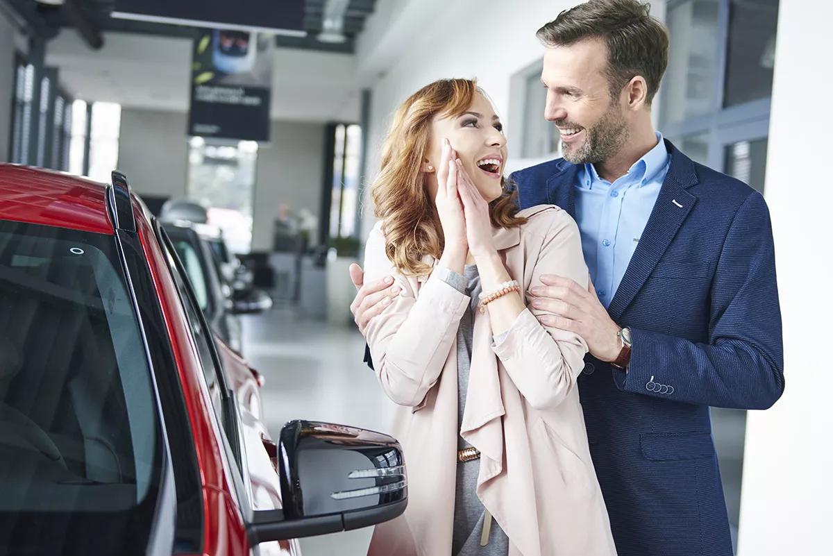 Femme avec son mari et heureuse de leur nouvelle voiture