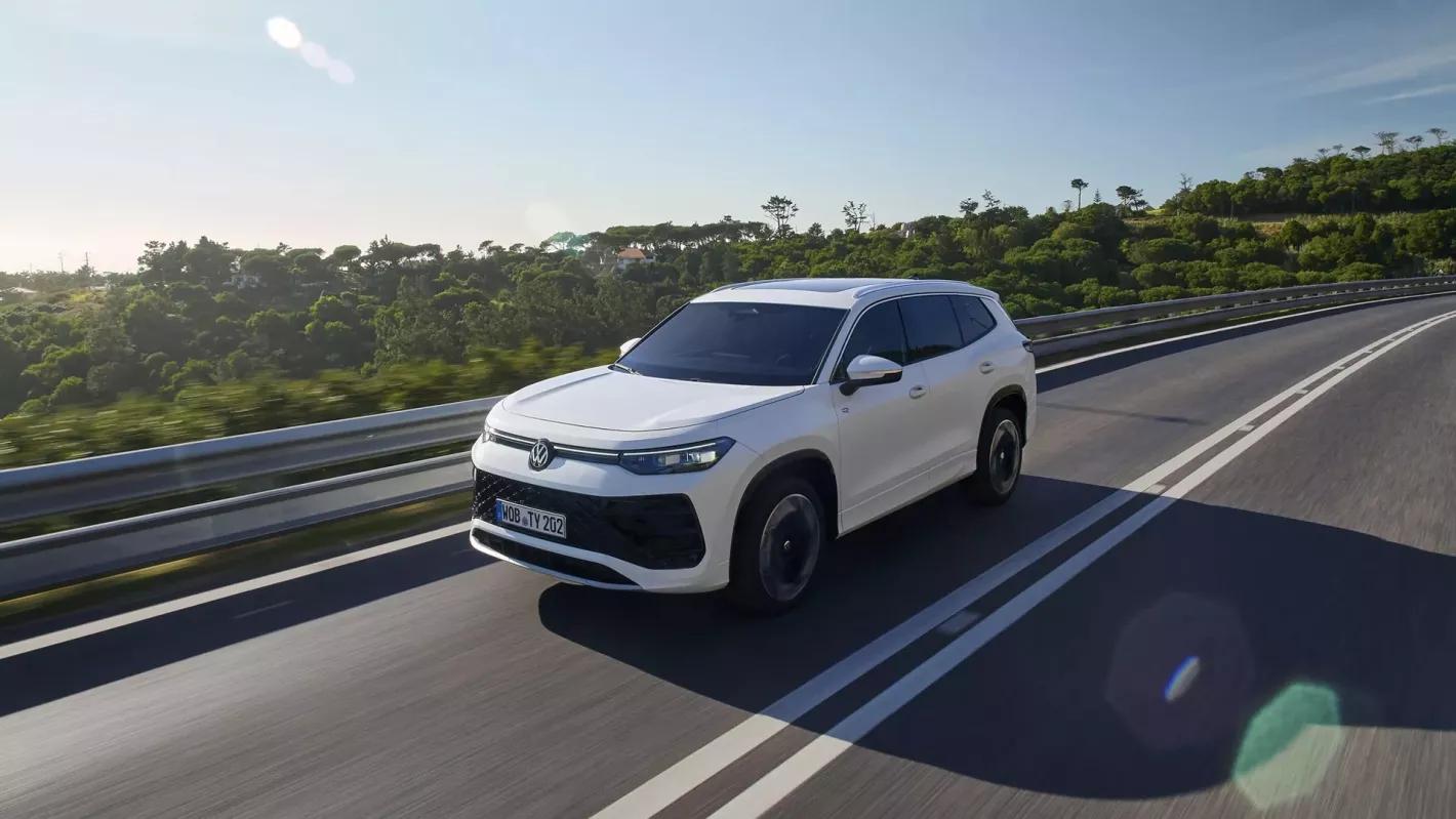 Voiture Volkswagen blanche roulant sur une route de vacances au sol